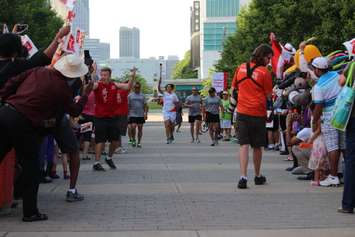 Olympic boxer Mary Spencer carries the flame during the Pan Am Torch Relay in Windsor, June 16, 2015. (Photo by Jason Viau)
