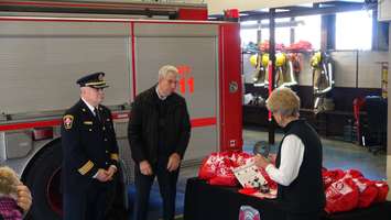 Members of Invisible Fence show Assistant Fire Chief Rick Scharf new animal rescue kits (Photo taken by Jake Kislinsky). 