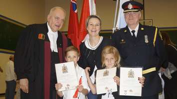 Svezlana Alekseeva and her children show off their Certificate of Canadian Citizenship with Justice George Springate (left) and Sarnia Police Chief Phil Nelson (right) following a swearing in ceremony at St. Patrick's High School. May 3, 2017 (Photo by Melanie Irwin)