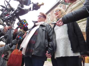 Laura Jackson and Andrea Silcox hold hands outside of the Woodstock courthouse, January 13, 2017. (Photo by Miranda Chant, Blackburn News.)