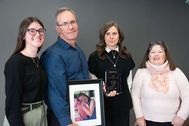 Sydney Vrolyk's family accepts the Kevin Schenk Legacy Award - (L to R): sister Abby Vrolyk, father John Vrolyk, mother Helen Van Sligtenhorst, and Kathleen Stinson of the Sarnia Accessibility Advisory Committee - Dec. 3/24 (Photo courtesy of City of Sarnia)