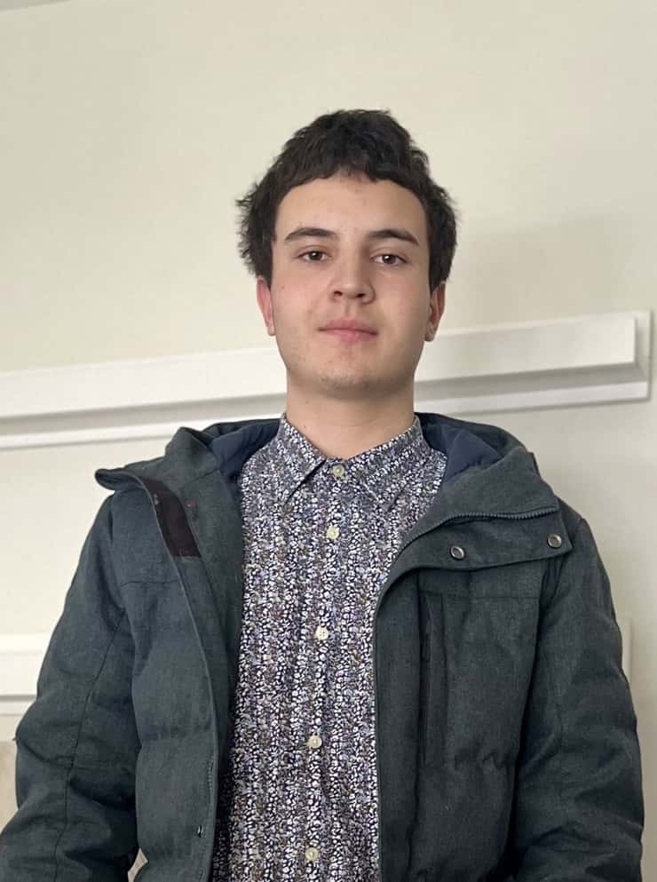 Photo of 17 year old Seamus Meneely wearing a blueish grey jacket and button up shirt.
