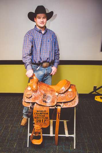 Foster stands next to his award for placing first in the steer wrestling competition at the 48th International Finals Rodeo in Oklahoma City. January 2018. (Photo courtesy of Emily Gethke Photography)