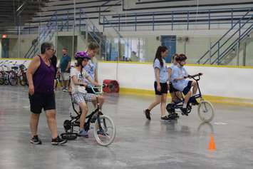Learning how to ride a bike with the help of volunteers at the iCan Bike Camp in Chatham. July 13, 2016. (Photo by Natalia Vega)