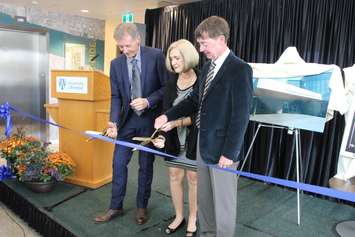 School President Alan Wildeman helps Stephen and Vicki Adams cut the ribbon for UWindsor's new Stephen and Vicki Adams Welcome Centre, October 2, 2015. (Photo by Mike Vlasveld)