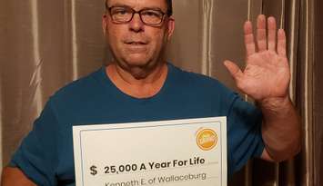 Kenneth Everaert holding up his cheque from OLG after winning $25K for life on a Daily Grand ticket. Photo via OLG.