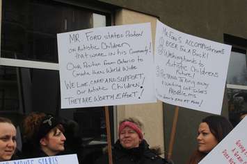 Demonstrators hold up signs at a rally outside the Ministry of Children, Community and Social Services field office in Windsor, February 14, 2019. Photo by Mark Brown/Blackburn News.