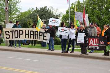 Protesters gather outside the Waterfront Hotel in downtown Windsor during Prime Minister Stephen Harper's visit to the city, May 13, 2015. (Photo by Jason Viau)
