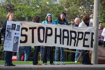 Protesters gather outside the Waterfront Hotel in downtown Windsor during Prime Minister Stephen Harper's visit to the city, May 13, 2015. (Photo by Jason Viau)