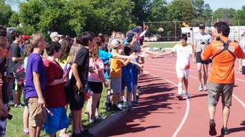 Torchbearer Nathan Oliphant high-fives former friends at Sarnia Pan Am torch run June 16, 2015 (BlackburnNews.com Photo by Briana Carnegie)
