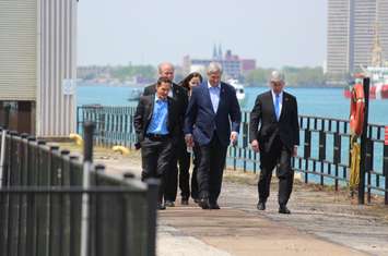 Prime Minister Stephen Harper (middle), Michigan Gov. Rick Snyder (right) and members of the Howe family get set to unveil the name of Windsor-Detroit's new bridge, May 14, 2015. (Photo by Mike Vlasveld)