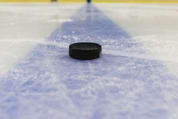 Detail blue line with puck on ice hockey rink. © Can Stock Photo / fotoduki