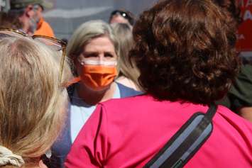 Ontario NDP Leader Andrea Horwath, in mask, listens to a supporter outside Ron LeClairs campaign headquarters in Essex, May 12, 2022. Photo by Mark Brown/WindsorNewsToday.ca.