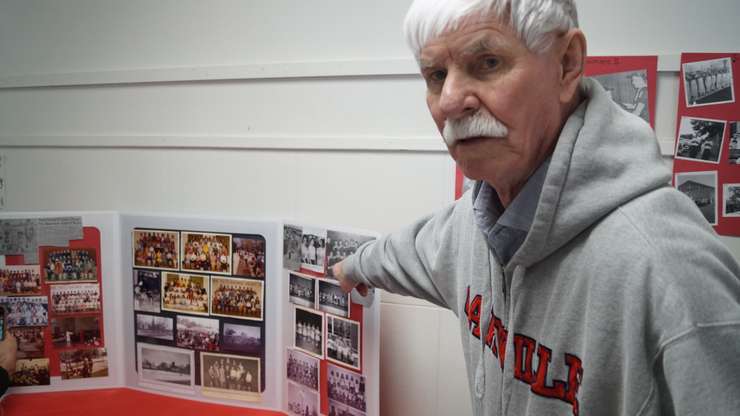 Norman Valliant showing photos of the former hockey team at Sacred Heart (Photo by: Lindsay Newman/Blackburn Media)