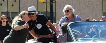 A fan steals a kiss from Kid Rock as RM founder Rob Myers looks on during the RM Sotheby's 40th Anniversary parade. June 21, 2019. (Photo by Matt Weverink)