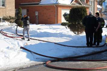 Homeowners return to the scene of a blaze in the 4200-block of Barton Cres., February 23, 2015. (Photo by Mike Vlasveld)
