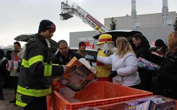 Windsor firefighter John McRae and the rest of his crew collect toys from Chrysler, being donated to Sparky's Toy Drive, November 20, 2014. (photo by Mike Vlasveld)