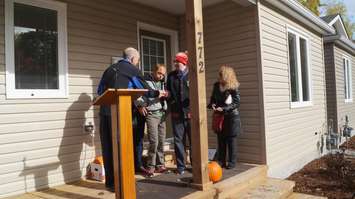 Sarnia-Lambton Habitat Board of Directors president Dr. David Butler presents Ryan Hastings and Adam Hutchinson with keys to their home. October 31, 2016 BlackburnNews.com photo by Leeya Morrow.