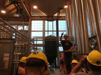 Cowbell Brew Master Stpehen Rich explains the vast operation in the cellar, including the kegging station and large beer storage units. August 3rd, 2017 (Photo by Ryan Drury)