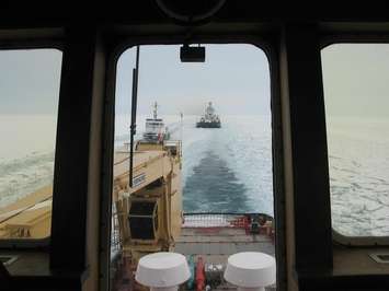 View through window of CCGS Samuel Risley  shows USCG cutter Bristol Bay assisting with an ice escort of the tug Everlast and barge Norman McLeod. (Submitted by CCG Commanding Officer John Cork)
