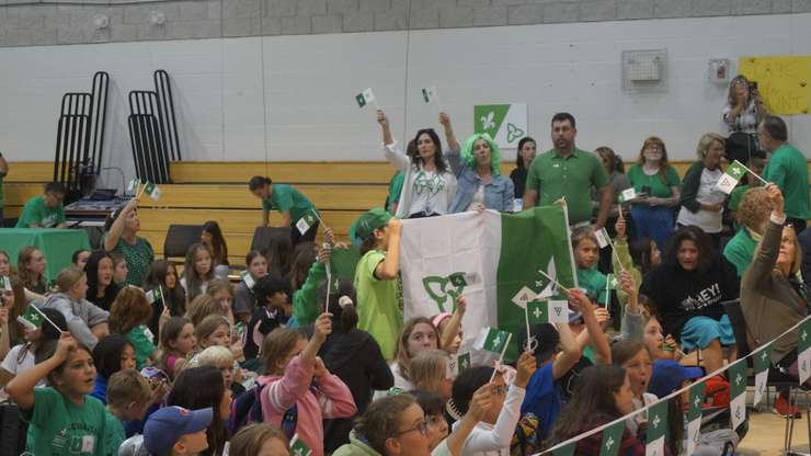 Students waving their flags at the Franco-Ontarian ceremony (Photo by: Lindsay Newman/ Blackburn Media)
