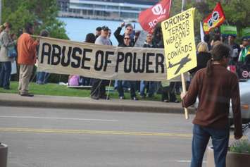 Protesters gather outside the Waterfront Hotel in downtown Windsor during Prime Minister Stephen Harper's visit to the city, May 13, 2015. (Photo by Jason Viau)