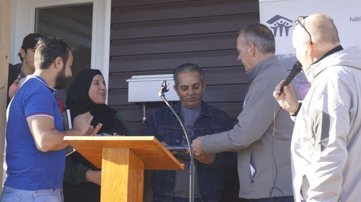 Habitat for Humanity Sarnia-Lambton Board Chair Martin Vrolyk gives keys to Hamza Khalifeh and his wife Najah. December 8, 2023. (Photo by Natalia Vega) 
