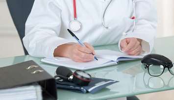 A doctor writing notes. File photo courtesy of © Can Stock Photo / photography33.