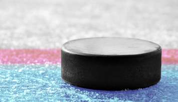 A hockey puck on an ice surface. © Can Stock Photo / vencavolrab