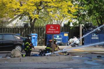 Firefighters aim streams of water at the flames at Le Chef Restaurant and Downtown Auto Shop on Wyandotte St. E in Windsor, May 23, 2016. (Photo by Adelle Loiselle)