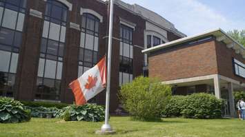 The flag at the former SCITS high school on Wellington Street is lowered for the last time. June 19, 2019 Photo by Melanie Irwin