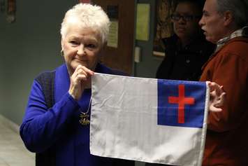 Cutting Edge International Church Pastor Shirley Walsh with the flag she wishes could fly at Windsor City Hall this summer, March 2, 2015. (Photo by Mike Vlasveld)