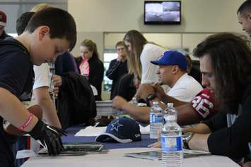 Luke Willson of the Seattle Seahawks, Tyrone Crawford of the Dallas Cowboys and Daryl Townsend of the Montreal Alouettes sign autographs at Performance Ford in Windsor, April 9, 2015. (Photo by Mike Vlasveld)
