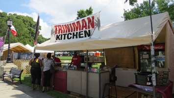 Joseph Alexander, owner of Triniman Kitchen, serves customers at Sunfest, July 8, 2016. (Photo by Samuel Gallant)