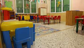 Interiors of a nursery class with coloredchairs and drawings of children hanging on the walls. © Can Stock Photo / ChiccoDodiFC
