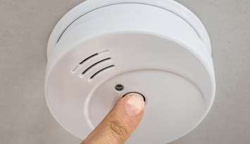 A person testing a smoke alarm. File photo courtesy of © Can Stock Photo / AndreyPopov