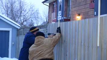 Floyd Porter drills protest signs on his property (Photo taken by Jake Kislinsky).