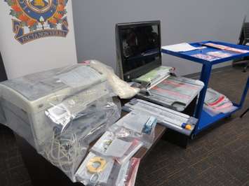 Counterfeiting equipment and money seized in a recent raid by London police at a home on Highbury Ave. (Photo by Miranda Chant, Blackburn News)