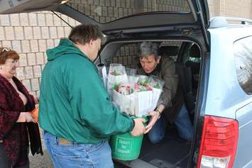 Volunteers load roses into the back of a minivan for delivery during the 17th annual Roses for Rotary fundraiser. April 5, 2017. (Photo by Matt Weverink)