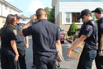 Chatham-Kent firefighters with carbon monoxide alarms in hand to give to those who don't have one, as part of the post fire reassurance initiative. September 6, 2016. (Photo by Natalia Vega)