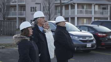 (From left to right) Karen McClintock, Tim Bechard, Marcy Draker and MPP Bob Bailey watch an HVAC system being lifted onto the roof of Pathways Health Centre for Children. 21 December 2022. Photo by Blackburn Media.  