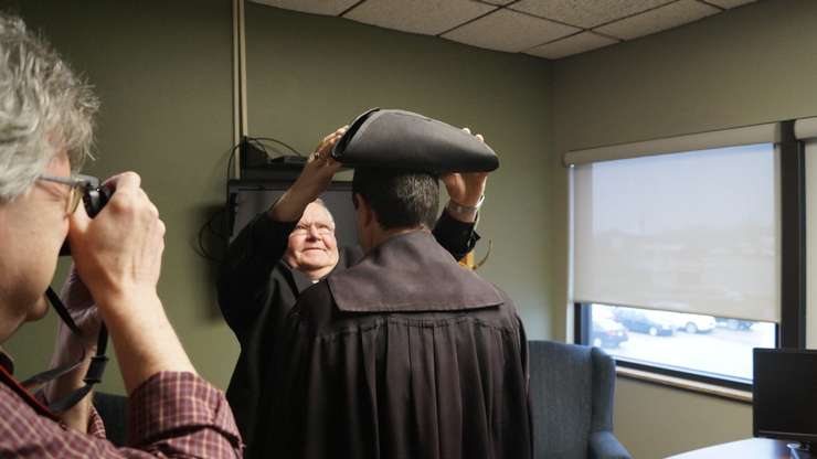 Former warden Bill Weber places hat on current Warden Kevin Marriott. December 7, 2022. (Photo by Natalia Vega)