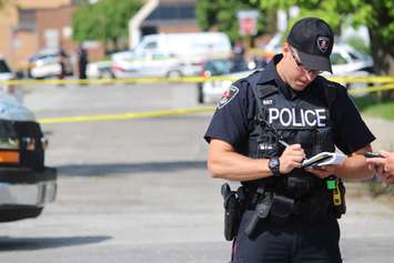 Police interview witnesses after an apparent homicide in the 500 block of Brant St., June 4, 2015. (Photo by Jason Viau)