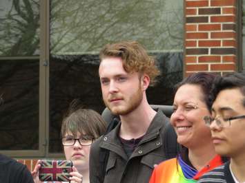 Riley Hamilton, a Grade 12 student at College Avenue Secondary School, watches as the pride and transgender flags are raised at the Thames Valley District School Board office on Dundas St., April 19. 2017. (Photo by Miranda Chant, Blackburn News.)