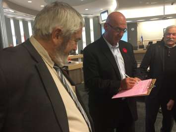 Lakeshore Deputy Mayor Al Fazio at Council Chambers at the Essex Civic Centre on November 5, 2014 is flanked by Lakeshore Mayor Tom Bain (L) and Essex Mayor Ron McDermott (R) as he signs a petition opposing the pending closure of the obstetrics ward at Leamington District Memorial Hospital. (Photo by Ricardo Veneza)