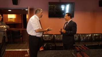 Economic Development and Infrastructure Minister Brad Duguid talks to local deaf resident about accessible hearing tools for viewing Imperial Theatre plays. May 29, 2015 (BlackburnNews.com Photo by Briana Carnegie).