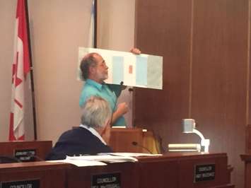 Cathcart resident and avid cyclist Ian Hope presents to Sarnia council Monday September 14, demonstrating possible scenarios using magnets of parked cars and bicycles on a steel board. (BlackburnNews.com Photo by Briana Carnegie)