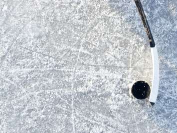 Hockey stick and puck background on ice.  © Can Stock Photo / bradcalkins