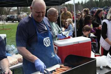Optimist Club of Chatham member Lorenzo Vosazzi cooks hot dogs for a line of hungry residents in Kingston Park on Monday. (photo by Michael Hugall) 