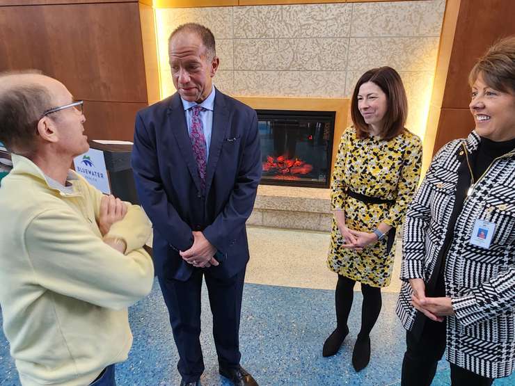 Cancer patient Fernando Penedo (L) speaks with Joe Wolf (NOVA), Kathy Alexander (BWHF), and Paula Reaume Zimmer (BWH) - Mar. 18/24 (Blackburn Media Photo by Josh Boyce)